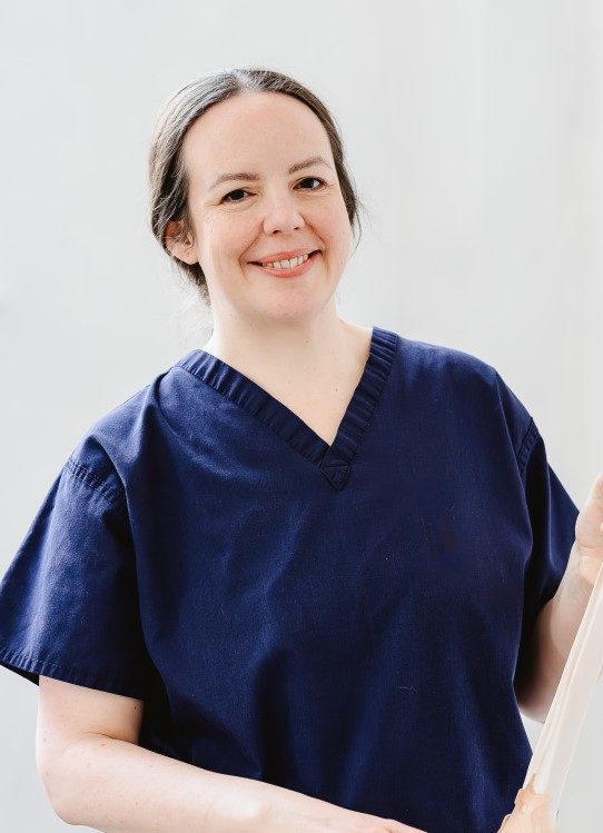 Professional osteopath at work with educational anatomical model